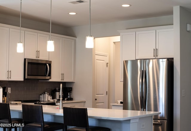 2960 Needlegrass Dr, Beaufort, SC 29902 - kitchen with a kitchen bar, appliances with stainless steel finishes, hanging light fixtures, tasteful backsplash, and light countertops
