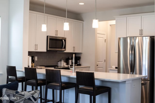 2960 Needlegrass Dr, Beaufort, SC 29902 - kitchen featuring light countertops, decorative backsplash, a breakfast bar, and stainless steel appliances
