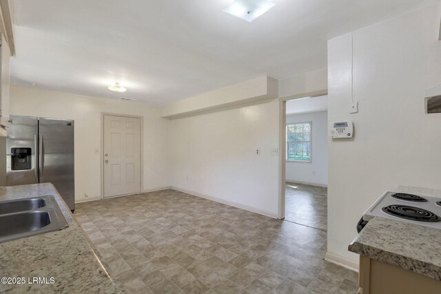 144 Middlefield Cir, Seabrook, SC 29940 - kitchen featuring a sink, baseboards, stainless steel fridge, and light countertops
