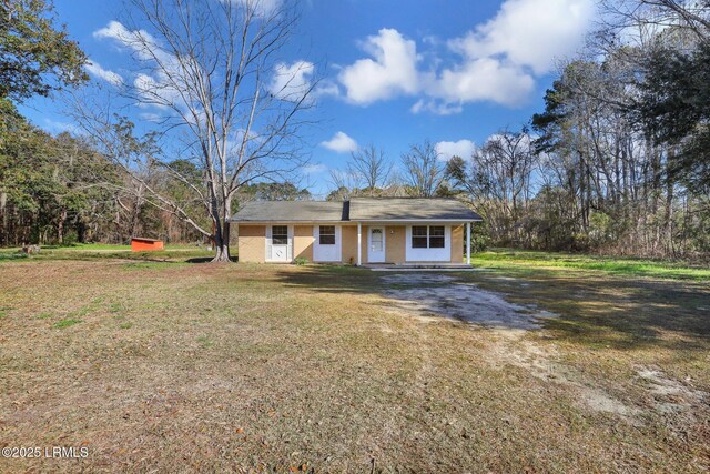 144 Middlefield Cir, Seabrook, SC 29940 - view of front facade with dirt driveway, covered porch, and a front yard