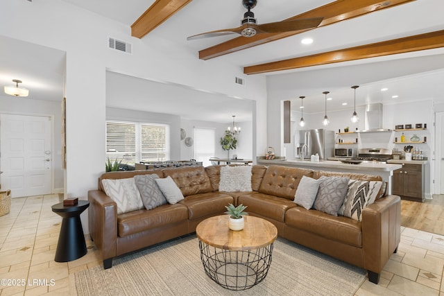 living room featuring beamed ceiling and ceiling fan with notable chandelier