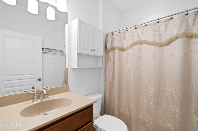 bathroom with vanity, curtained shower, and toilet