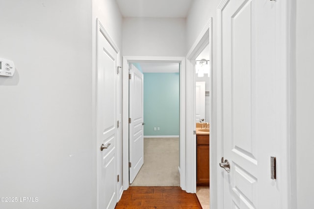 corridor with dark hardwood / wood-style floors and sink