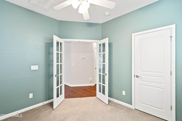 unfurnished bedroom featuring light colored carpet, ceiling fan, and french doors