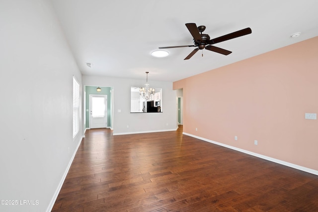 unfurnished living room with dark wood-type flooring and ceiling fan with notable chandelier