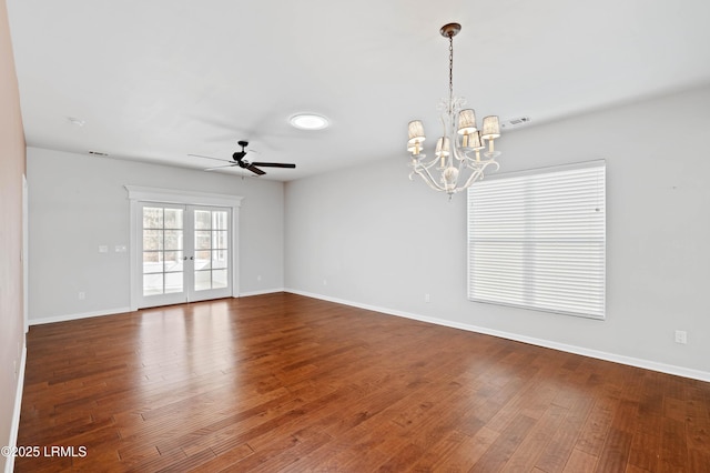 empty room with hardwood / wood-style flooring, ceiling fan with notable chandelier, and french doors