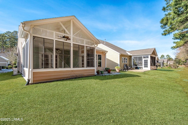 rear view of house featuring a lawn and a sunroom