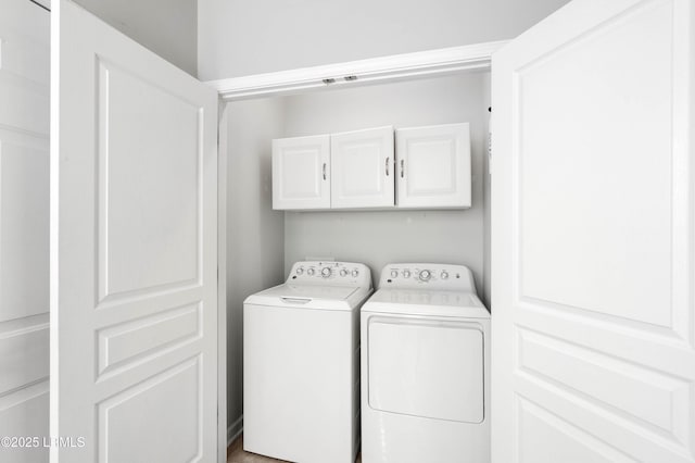 washroom featuring cabinets and washing machine and clothes dryer