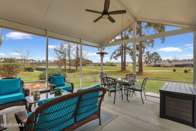 sunroom featuring lofted ceiling with beams and ceiling fan