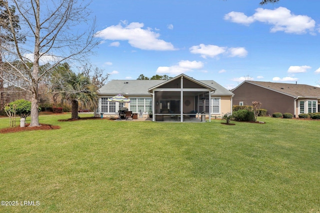 rear view of house featuring a yard and a sunroom