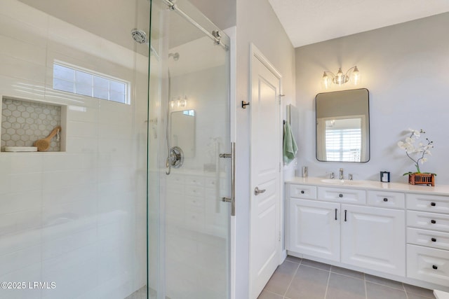 full bathroom featuring a stall shower, vanity, and tile patterned flooring