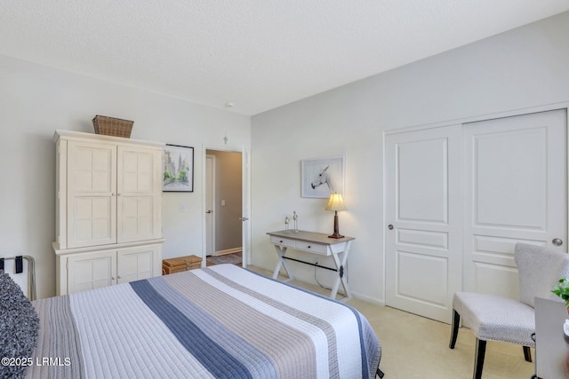 bedroom with light carpet, baseboards, a textured ceiling, and a closet