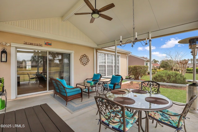 sunroom / solarium with ceiling fan with notable chandelier and lofted ceiling with beams