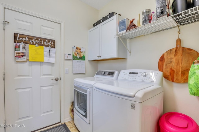 laundry room with cabinet space, washer and dryer, and light tile patterned flooring