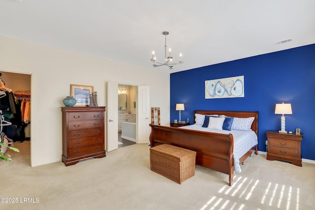 carpeted bedroom featuring visible vents, an inviting chandelier, a closet, ensuite bathroom, and a walk in closet