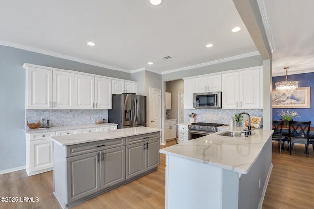 kitchen featuring a sink, gray cabinetry, stainless steel appliances, light wood-style floors, and a chandelier