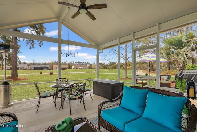 sunroom featuring lofted ceiling with beams and a ceiling fan