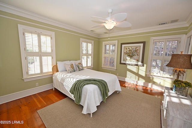 bedroom with crown molding, ceiling fan, and hardwood / wood-style floors