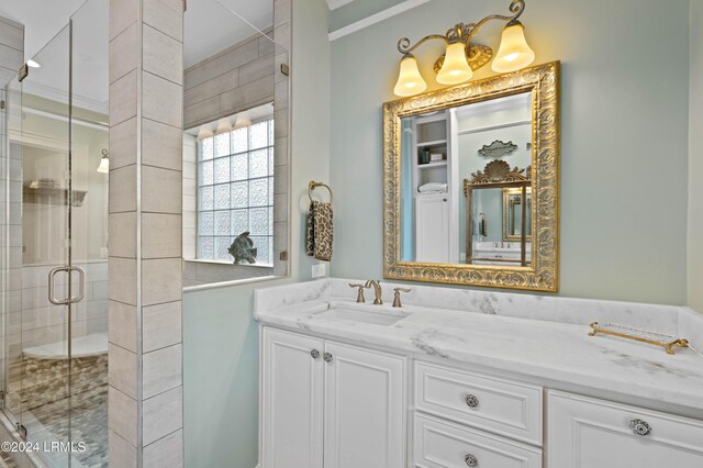 bathroom with vanity, crown molding, and a shower with door