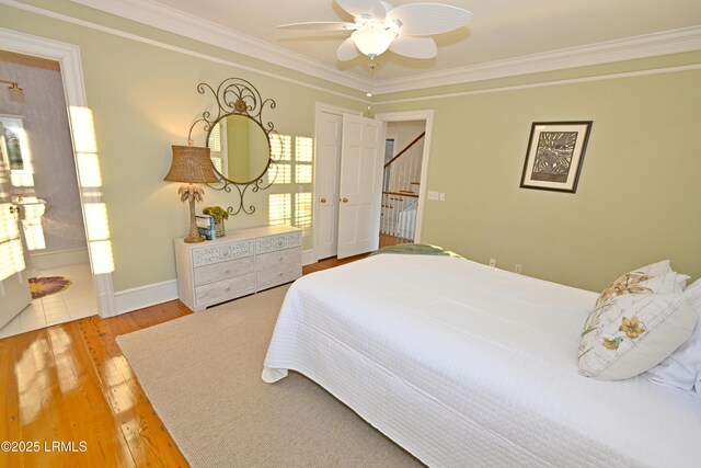 bedroom featuring crown molding, ceiling fan, wood-type flooring, and ensuite bathroom