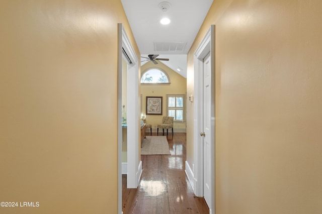 corridor featuring hardwood / wood-style flooring and vaulted ceiling