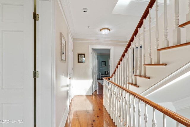 hall featuring light hardwood / wood-style flooring and ornamental molding