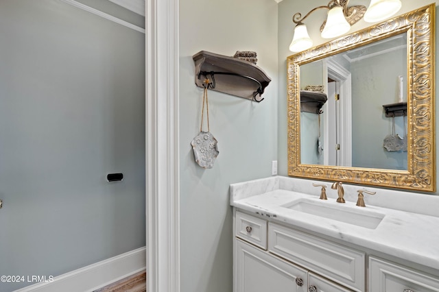 bathroom featuring ornamental molding, wood-type flooring, and vanity