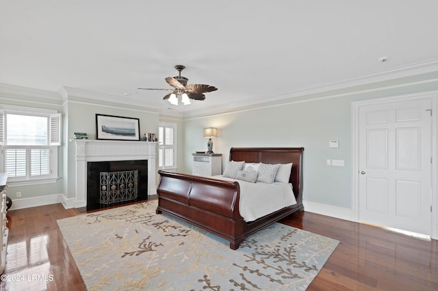 bedroom with ornamental molding, dark hardwood / wood-style floors, and ceiling fan