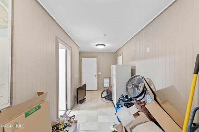 interior space featuring ornamental molding and wooden walls