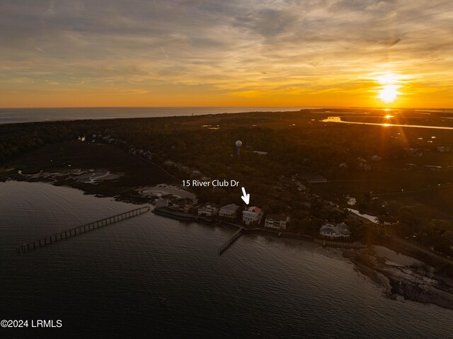 aerial view at dusk featuring a water view