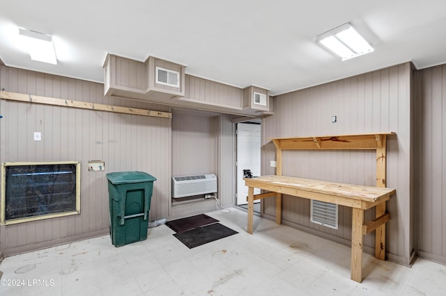 interior space with an AC wall unit, a workshop area, and wood walls