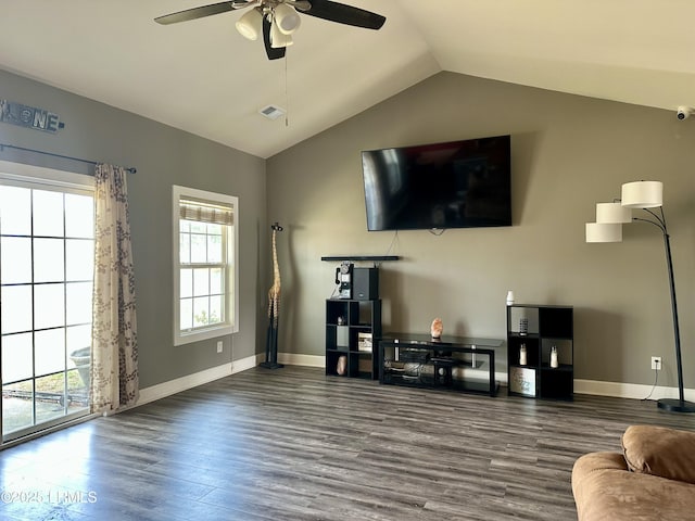 living area with vaulted ceiling, plenty of natural light, wood finished floors, and visible vents