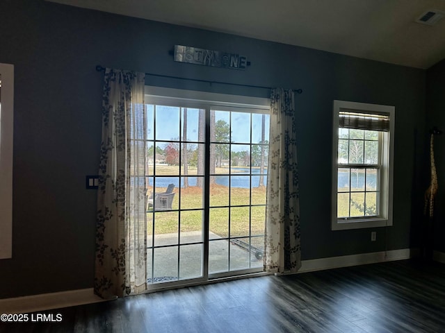 entryway featuring visible vents, baseboards, and wood finished floors