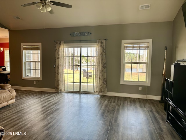 unfurnished living room featuring dark wood-type flooring, baseboards, and visible vents