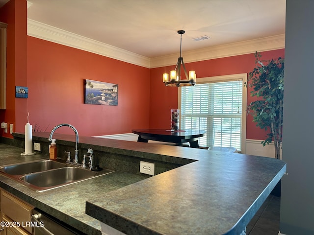 kitchen featuring visible vents, ornamental molding, a sink, dark countertops, and a chandelier