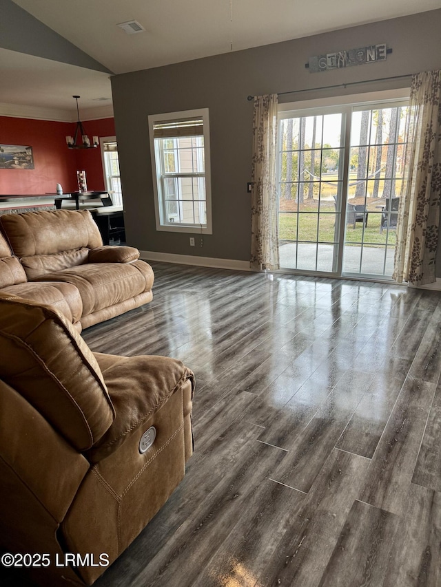 living room featuring a wealth of natural light, visible vents, baseboards, and wood finished floors