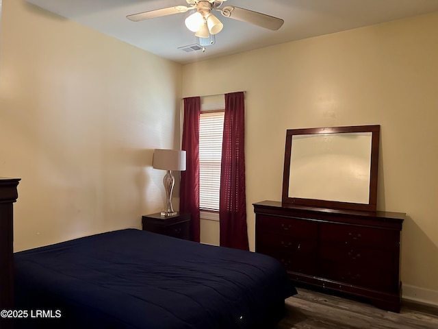 bedroom featuring wood finished floors, a ceiling fan, and visible vents