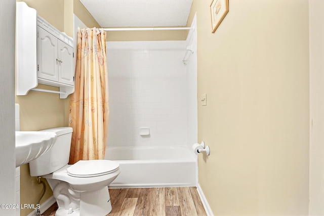 bathroom featuring shower / tub combo, baseboards, toilet, and wood finished floors