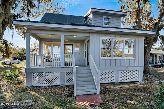 view of front of house with covered porch, metal roof, board and batten siding, and a ceiling fan