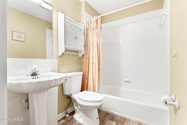 full bath featuring shower / bath combo with shower curtain, wood finished floors, and toilet