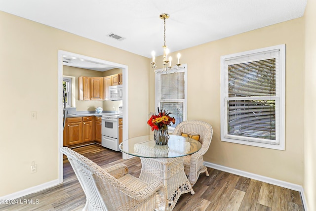 dining room featuring a notable chandelier, baseboards, and dark wood-style flooring