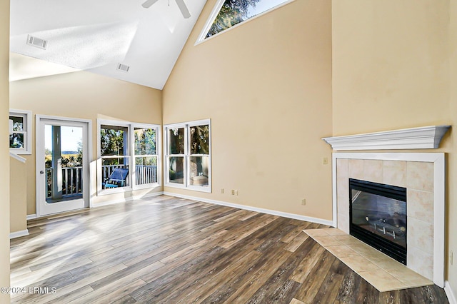 unfurnished living room featuring a ceiling fan, a fireplace, visible vents, and wood finished floors