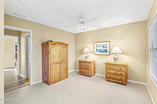 carpeted bedroom with a ceiling fan, visible vents, and baseboards