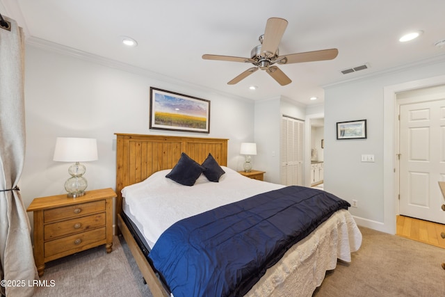 carpeted bedroom featuring ornamental molding, connected bathroom, ceiling fan, and a closet