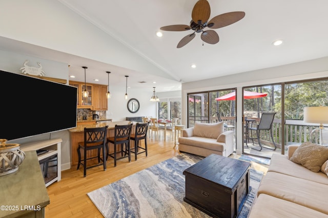 living room featuring ceiling fan, high vaulted ceiling, and light wood-type flooring