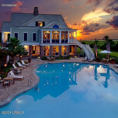 pool at dusk with a patio area