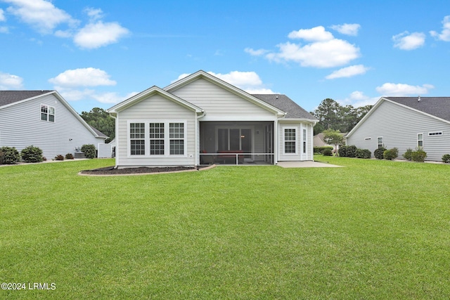 rear view of house with a patio area, a sunroom, and a lawn