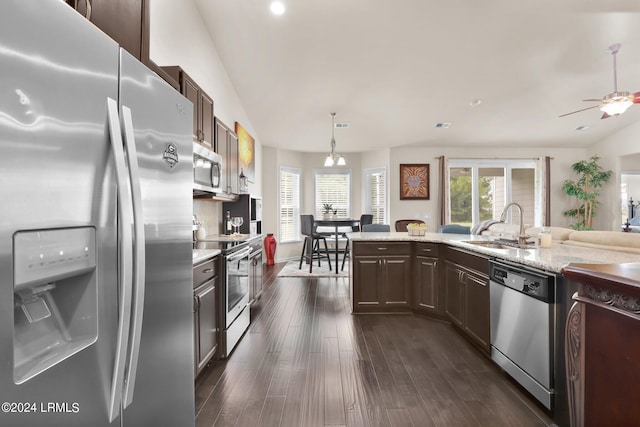 kitchen featuring appliances with stainless steel finishes, dark hardwood / wood-style floors, sink, hanging light fixtures, and dark brown cabinets