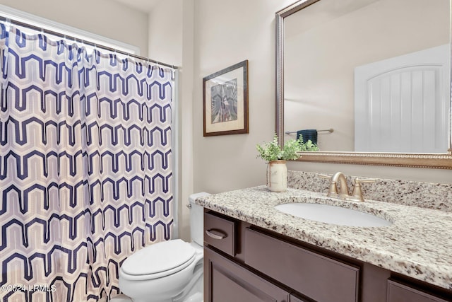 bathroom featuring vanity, curtained shower, and toilet