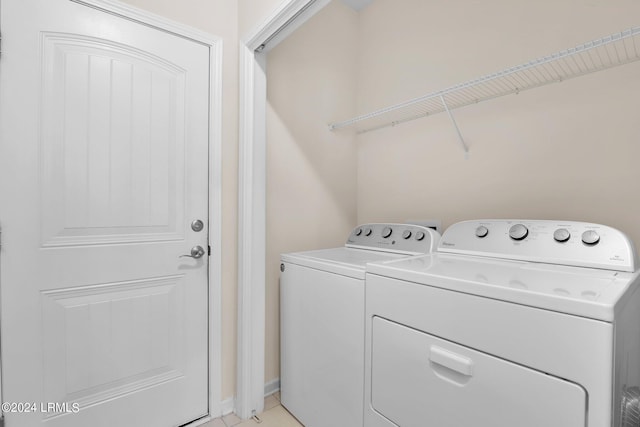 laundry room with washer and clothes dryer and light tile patterned flooring